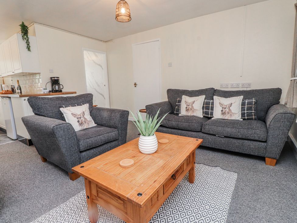 A living room with sofas and a coffee table at Hen Fecws Rhoshirwaun near Sarn Meyllteyrn