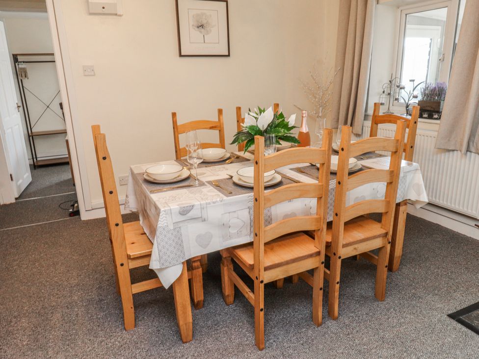 A dining room with a table set for a meal at Hen Fecws Rhoshirwaun near Sarn Meyllteyrn