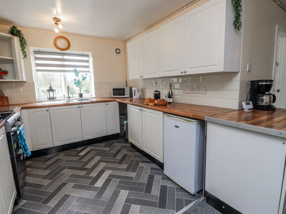 A kitchen with cabinets and a sink at Hen Fecws Rhoshirwaun near Sarn Meyllteyrn