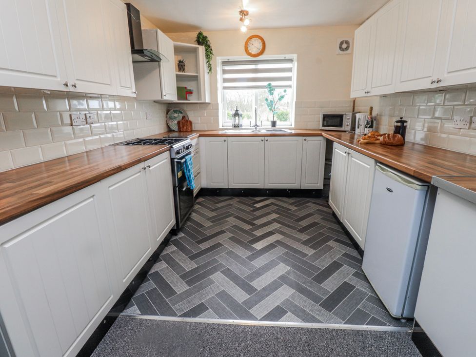 A kitchen with cabinets and appliances at Hen Fecws Rhoshirwaun near Sarn Meyllteyrn