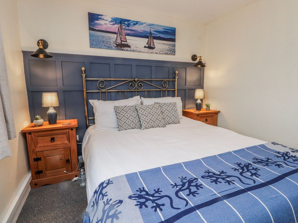 A bedroom with a bed and bedside tables at Hen Fecws in Rhoshirwaun near Sarn Meyllteyrn