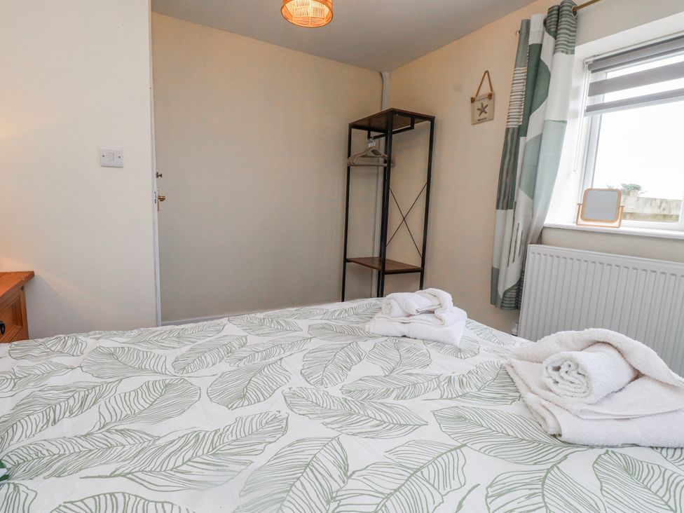 A bedroom with a bed and towels on it at Hen Fecws in Rhoshirwaun near Sarn Meyllteyrn