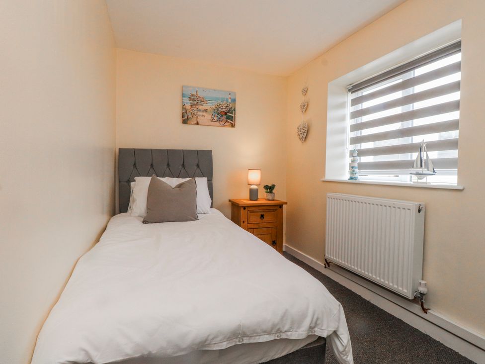 A bedroom with a single bed and bedside table at Hen Fecws in Rhoshirwaun near Sarn Meyllteyrn