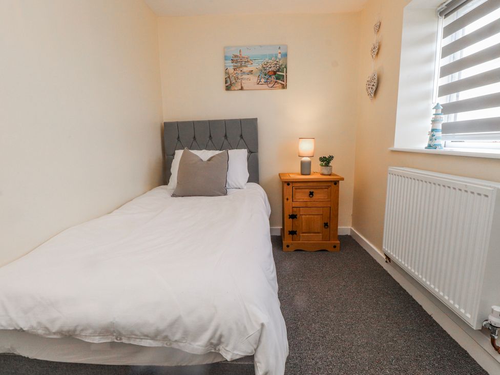 A bedroom with a single bed and side table at Hen Fecws Rhoshirwaun near Sarn Meyllteyrn