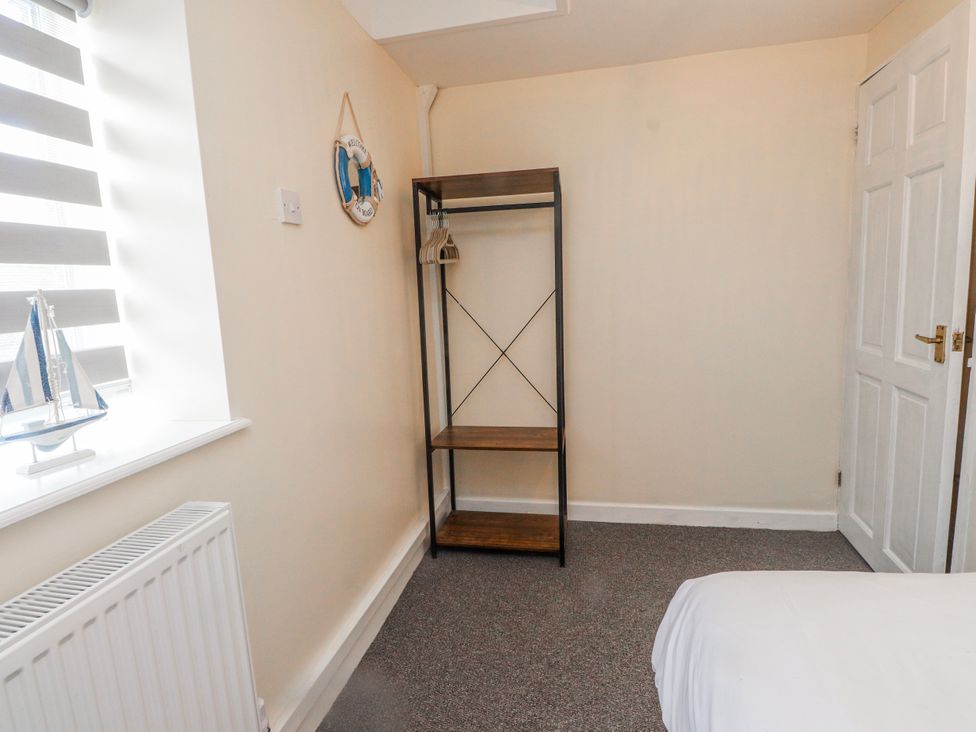 A bedroom with a shelf and a window at Hen Fecws Rhoshirwaun near Sarn Meyllteyrn