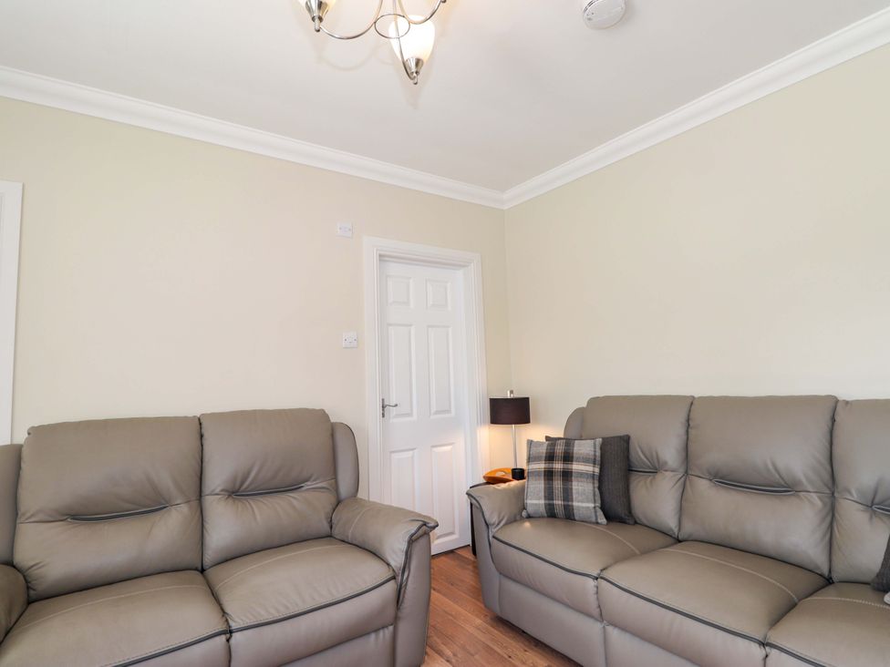 A living room with sofas and a lamp at Craig Cottage in Banff