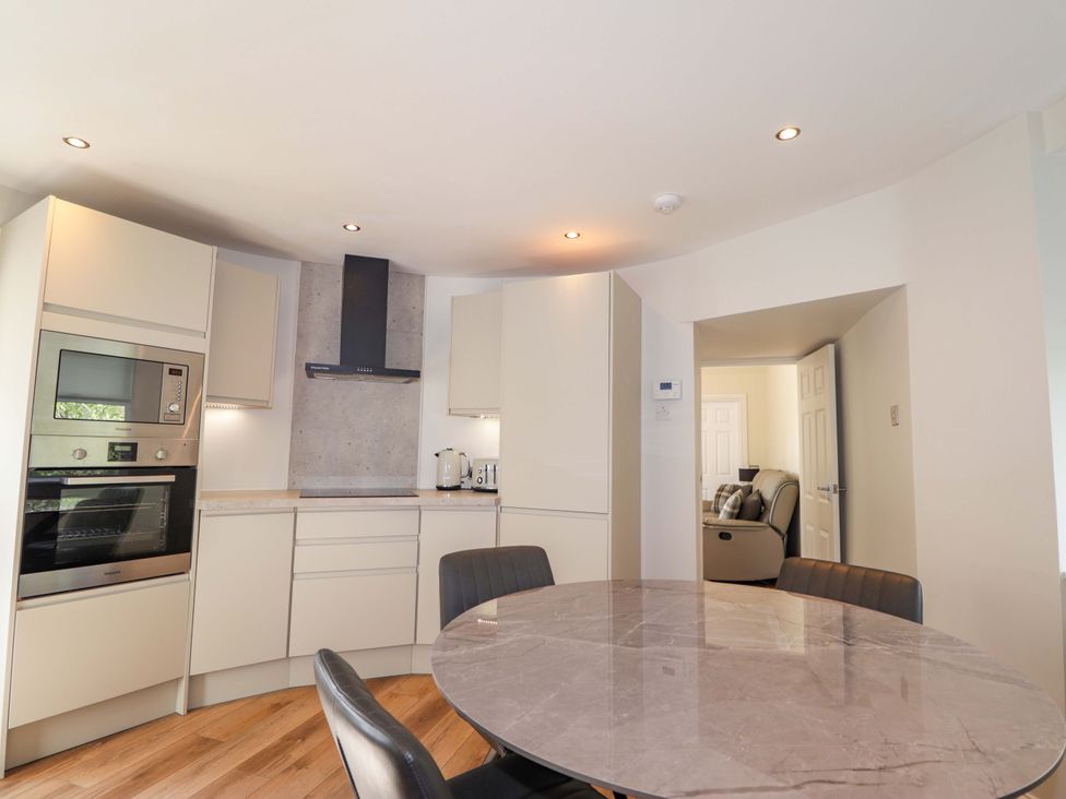A kitchen with modern appliances and a table at Craig Cottage in Banff
