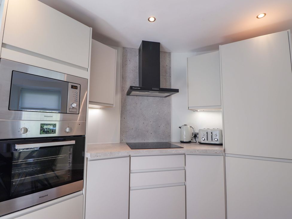 A kitchen with oven, microwave, extractor hood, kettle and toaster at Craig Cottage in Banff