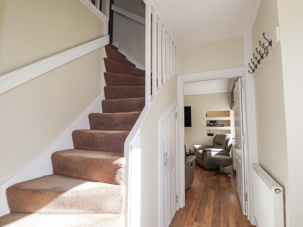A hallway with a staircase and doorway at Craig Cottage in Banff