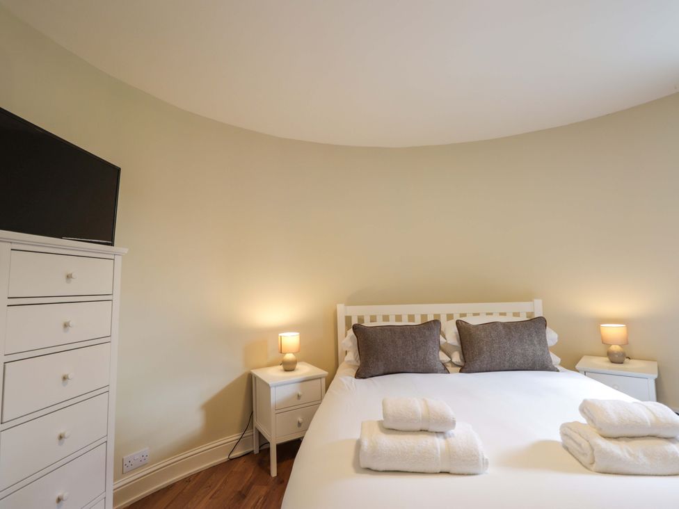 A bedroom with a bed and television at Craig Cottage in Banff