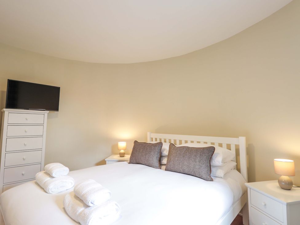 A bedroom with a bed, television, and bedside tables at Craig Cottage in Banff