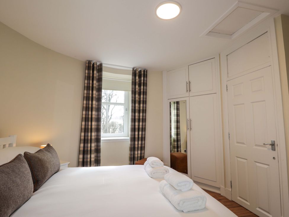 A bedroom with a bed and window at Craig Cottage in Banff