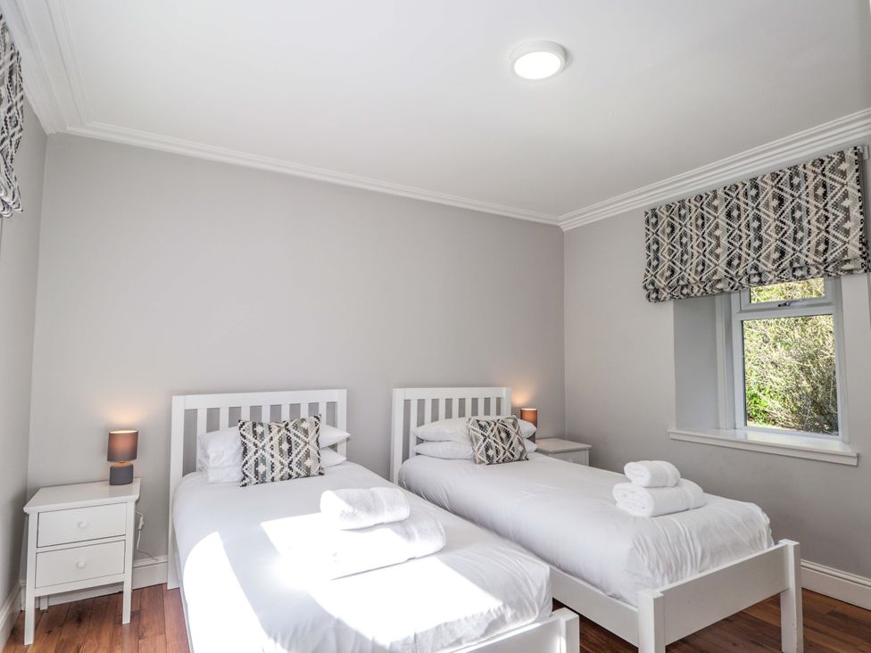 A bedroom with two single beds and a window at Craig Cottage in Banff