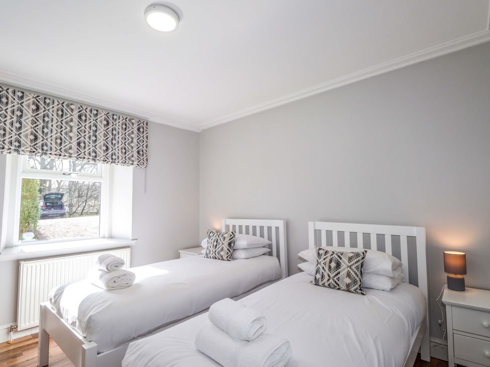 A bedroom with two beds and a window at Craig Cottage in Banff