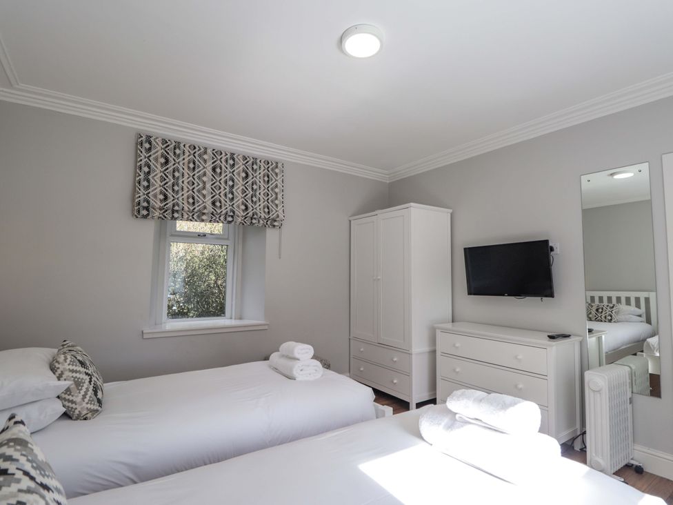A bedroom with two beds and a television at Craig Cottage in Banff