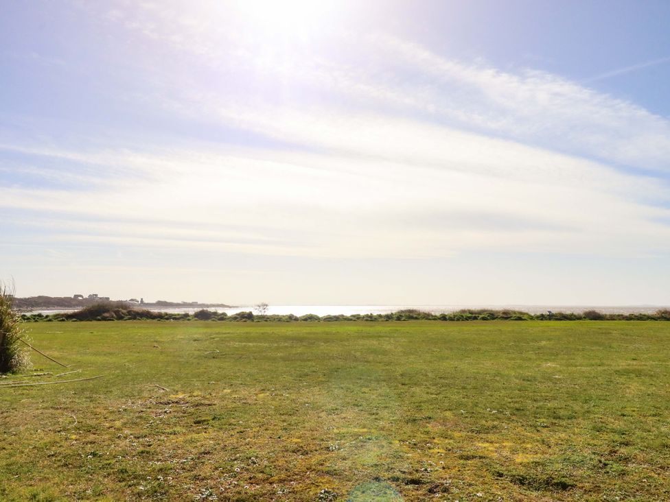 A view of grass and water with a clear sky at Plot B2 Crozzers Place Morecambe