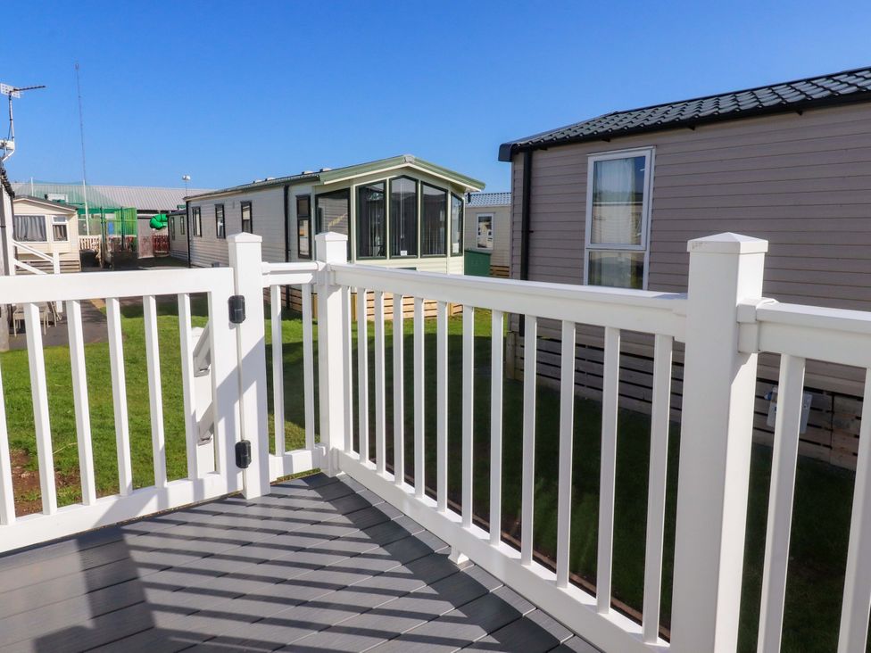 An outdoor deck with railing and view of mobile homes at Plot B2 Crozzers Place in Morecambe