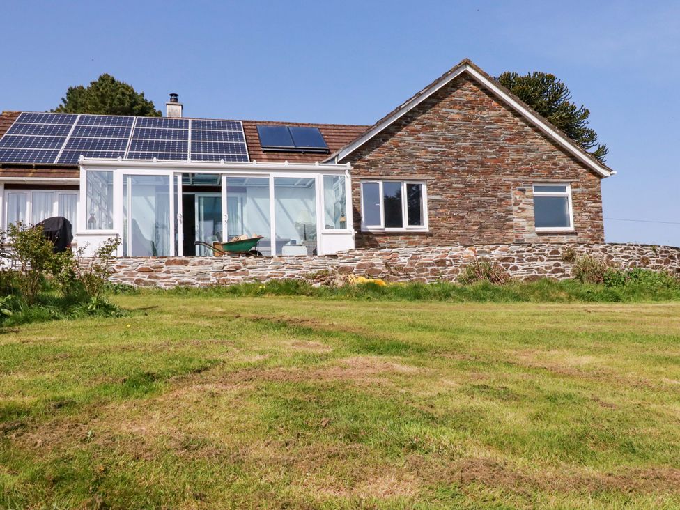 A house with solar panels and a wall at Tregoning in Lostwithiel