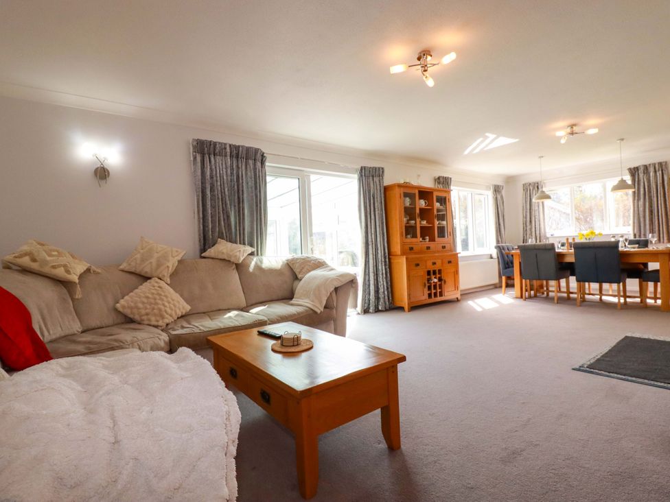A living room with a sofa and dining table at Tregoning in Lostwithiel