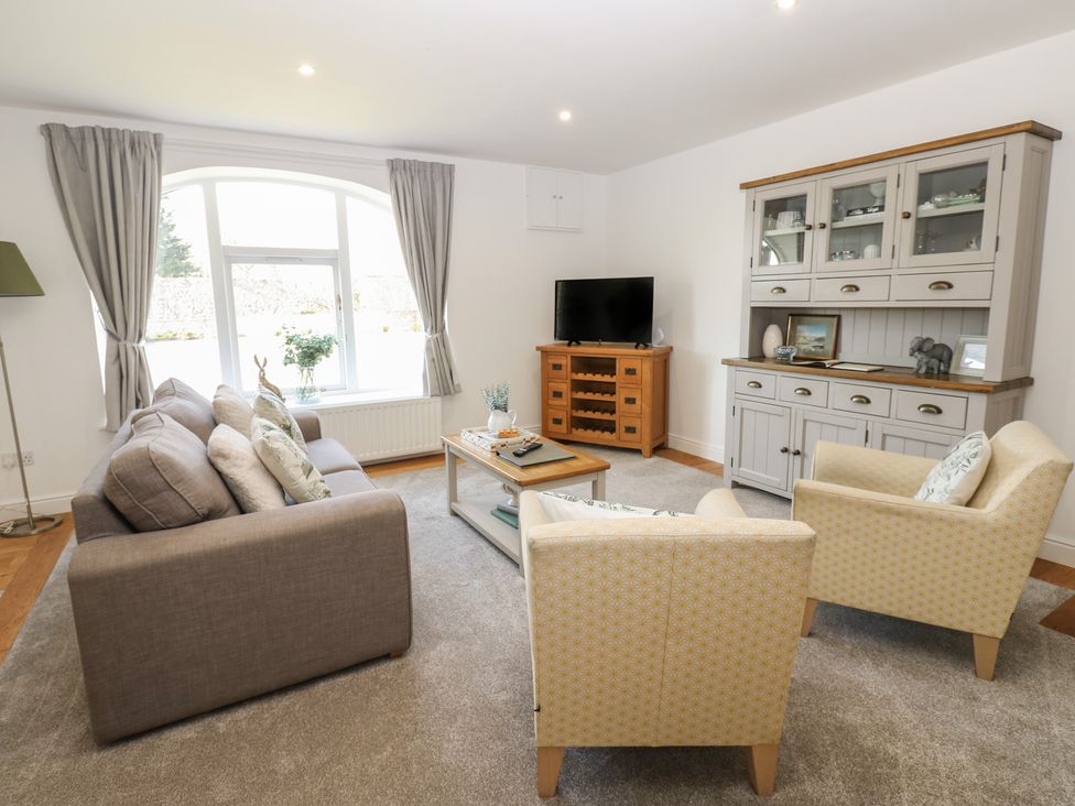 A living room with a sofa, armchairs, and a tv at Castle View Cottage Bedale
