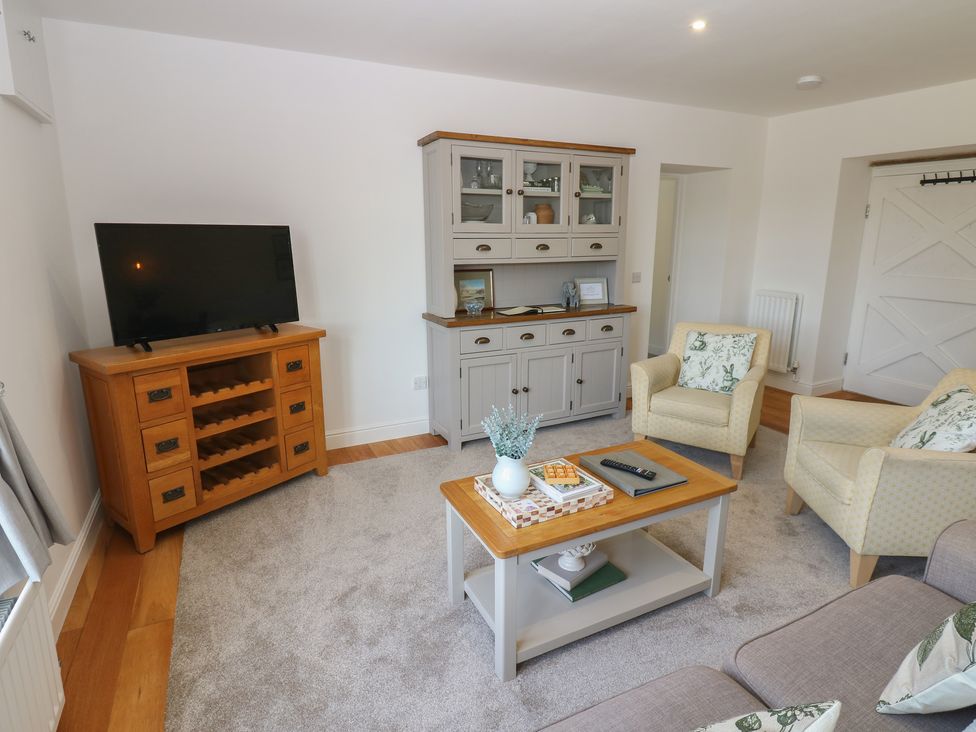 A living room with furniture including a television and a cabinet at Castle View Cottage in Bedale