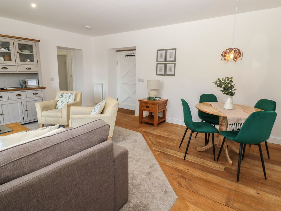 A living room with sofa and dining area at Castle View Cottage Bedale