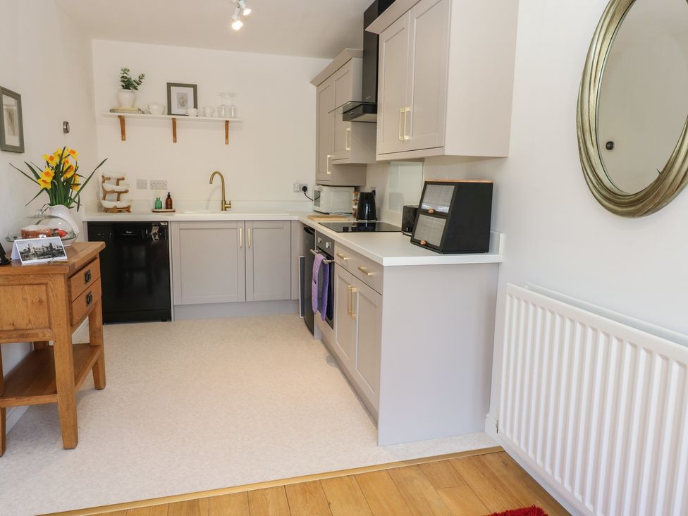 A kitchen with cabinets and appliances at Castle View Cottage Bedale