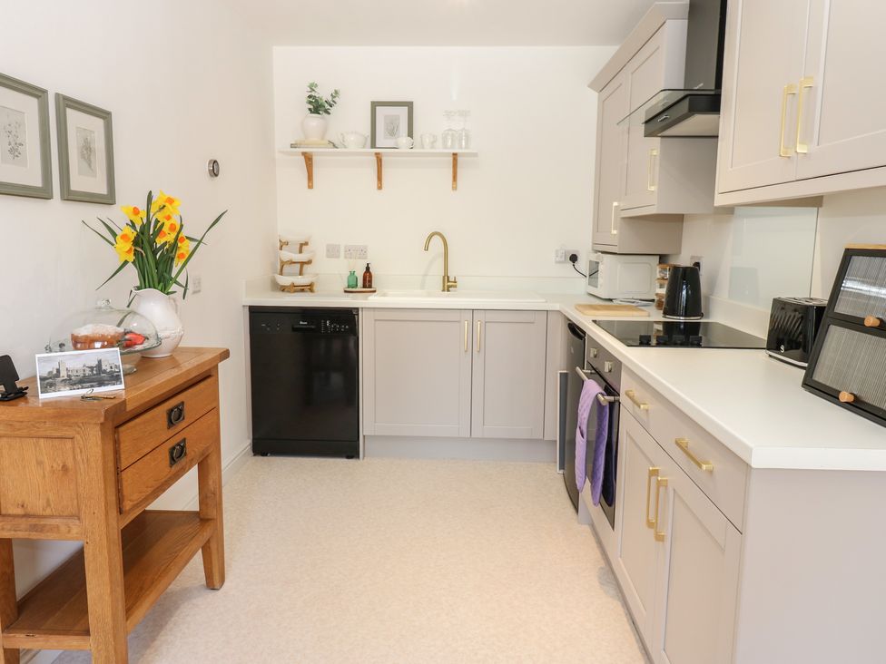 A kitchen with appliances and a wooden table at Castle View Cottage Bedale
