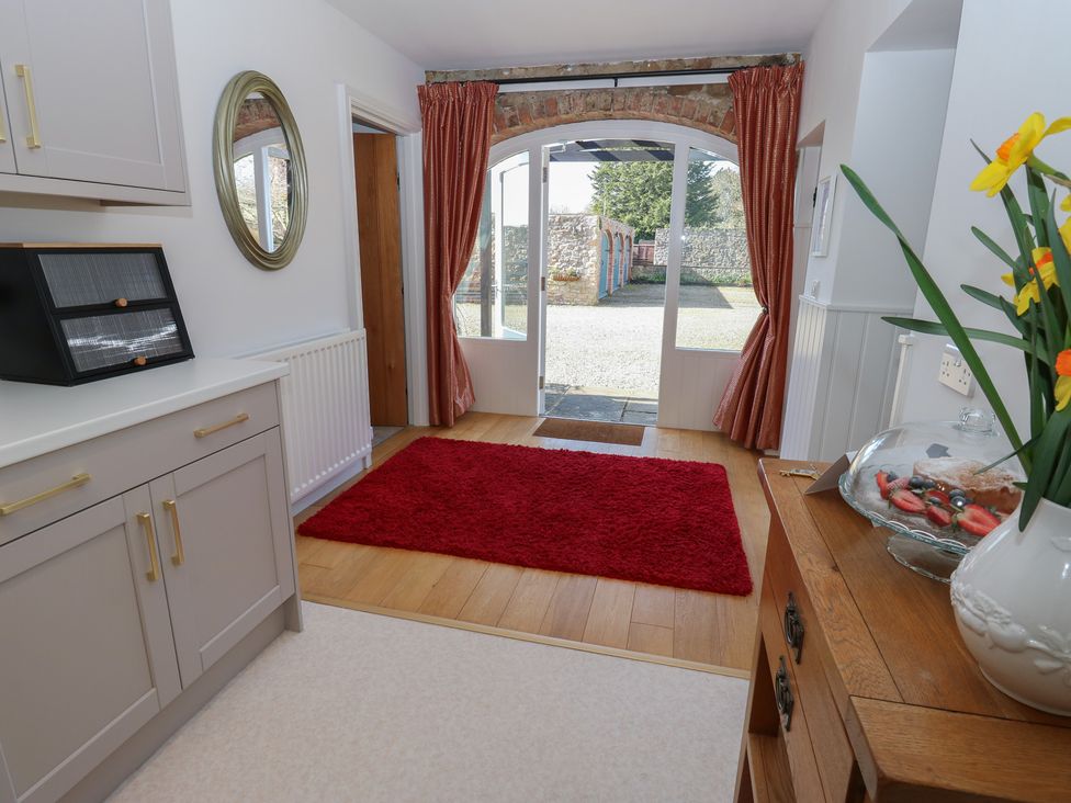 A hallway with a mirror and a rug at Castle View Cottage in Bedale