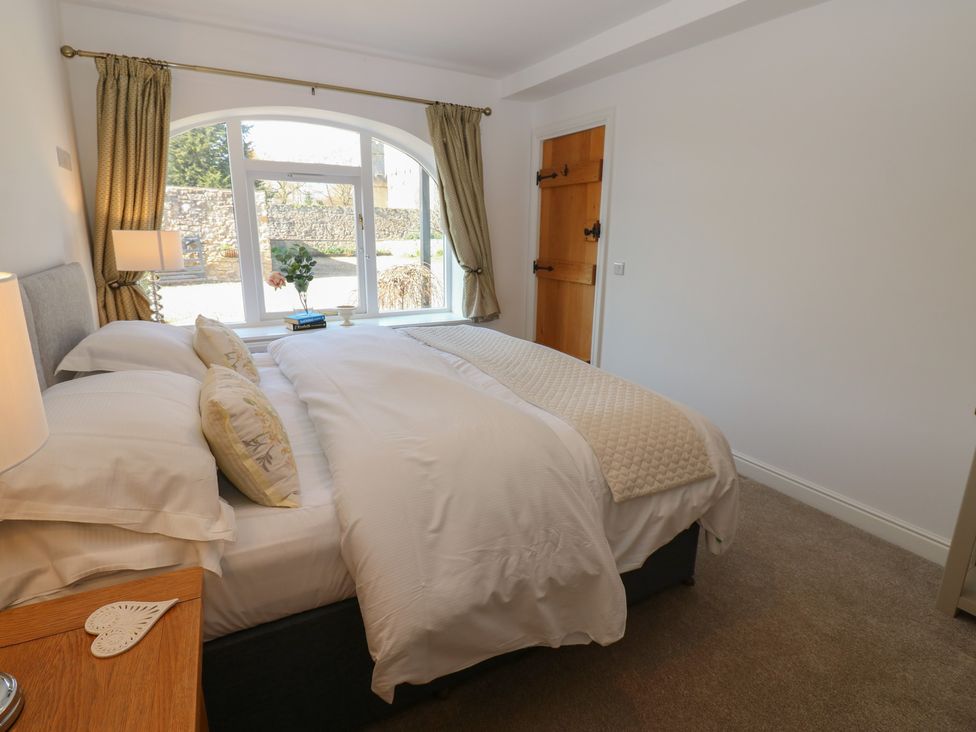 A bedroom with a bed and lamp at Castle View Cottage in Bedale