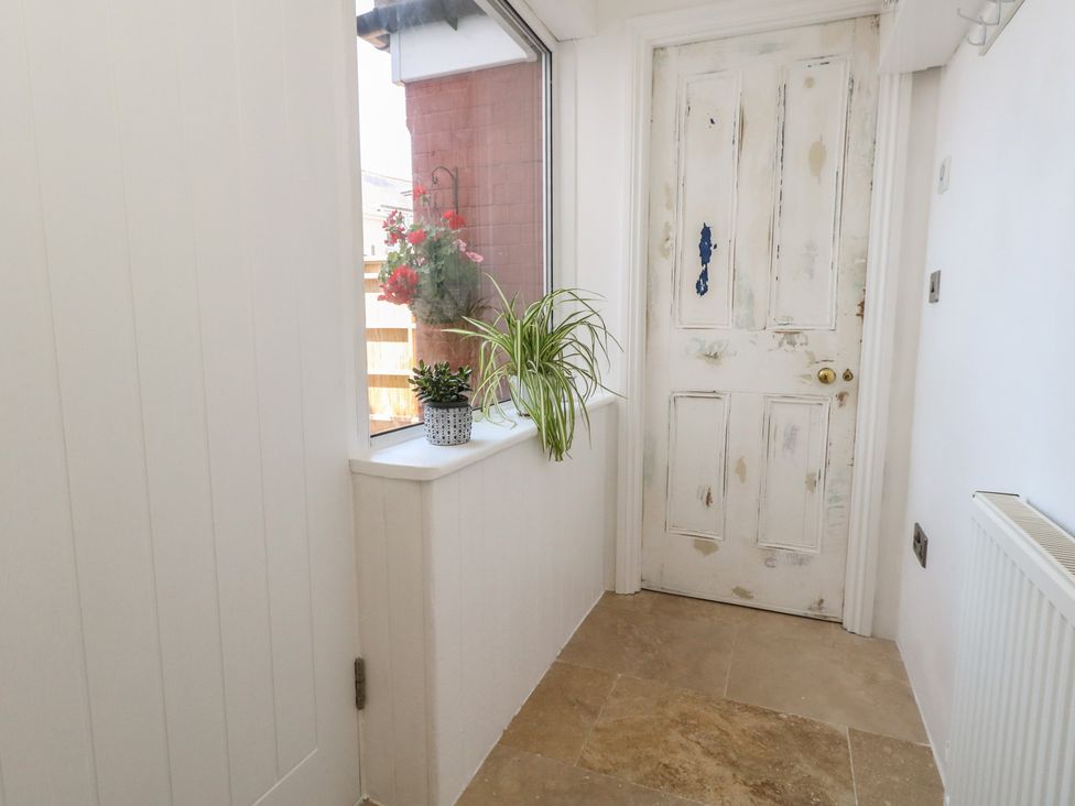 A hallway with a door and a window at Tipsy Turtle in Weymouth