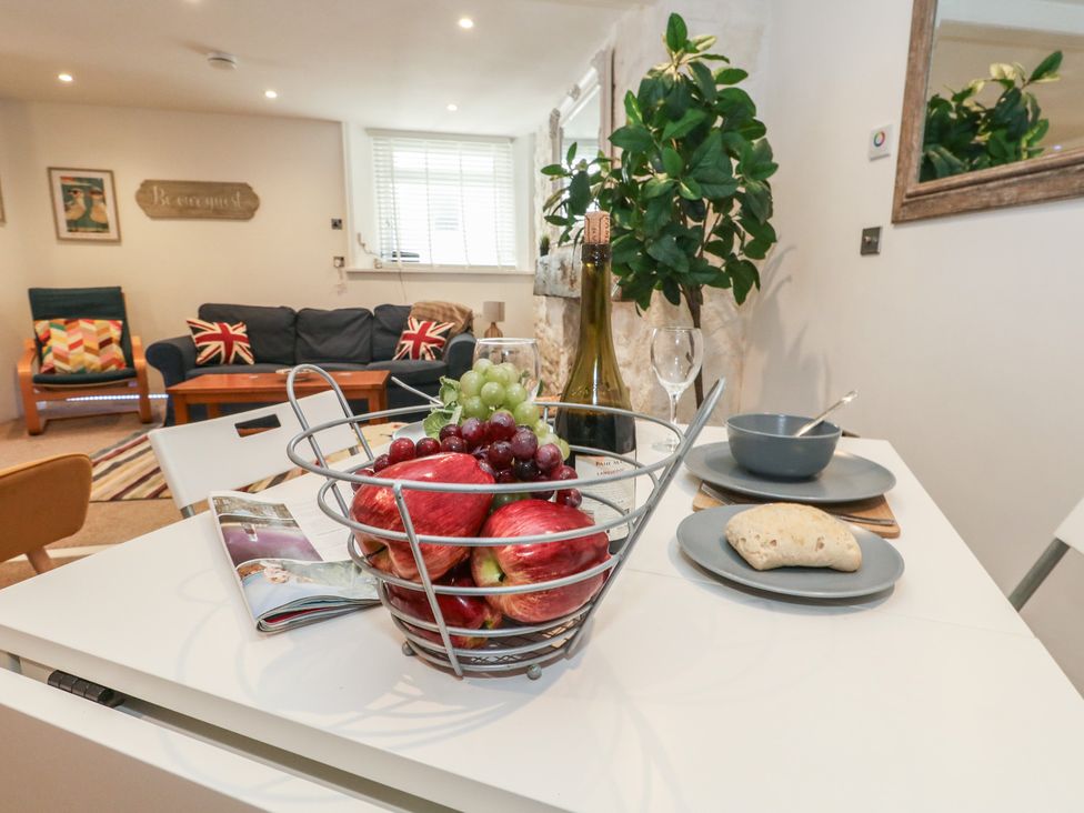 A dining table with a fruit basket and dishes at Tipsy Turtle in Weymouth