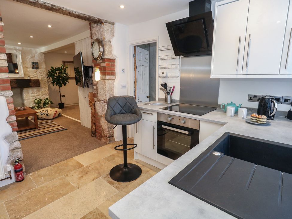 A kitchen with modern appliances and a seating area at Tipsy Turtle in Weymouth