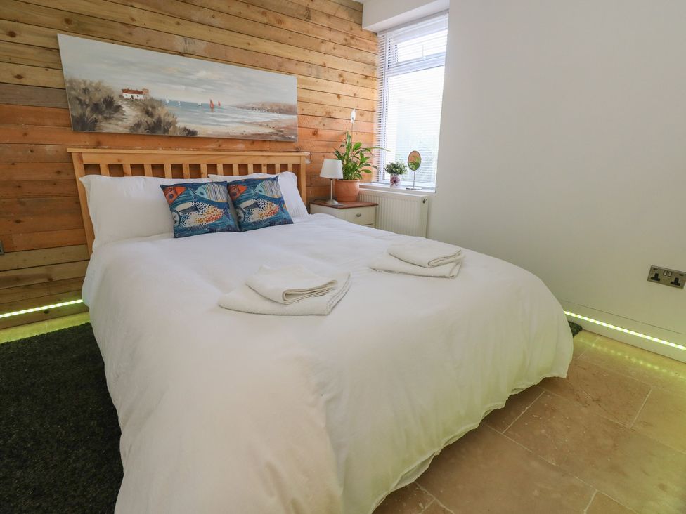 A bedroom with a bed and bedside table at Tipsy Turtle in Weymouth