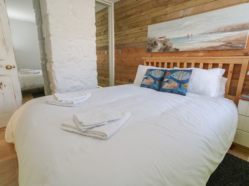 A bedroom with a bed and towels at Tipsy Turtle in Weymouth