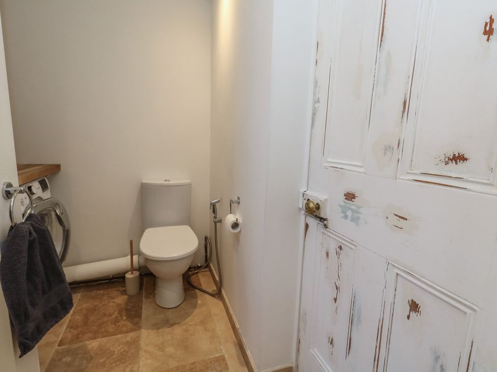 A bathroom with a toilet and washing machine at Tipsy Turtle in Weymouth