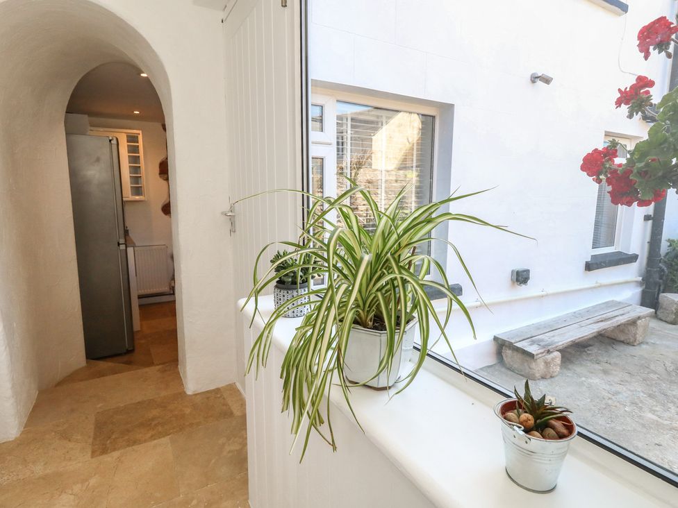 A hallway with potted plants and a refrigerator at Tipsy Turtle in Weymouth