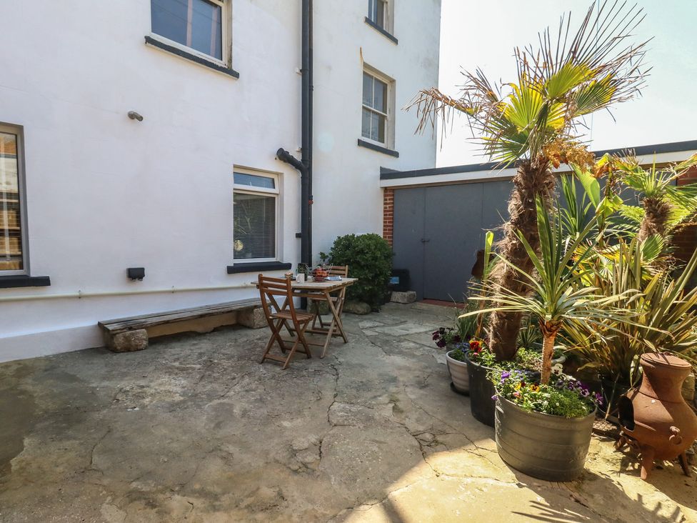 An outdoor seating area with a table and chairs at Tipsy Turtle in Weymouth