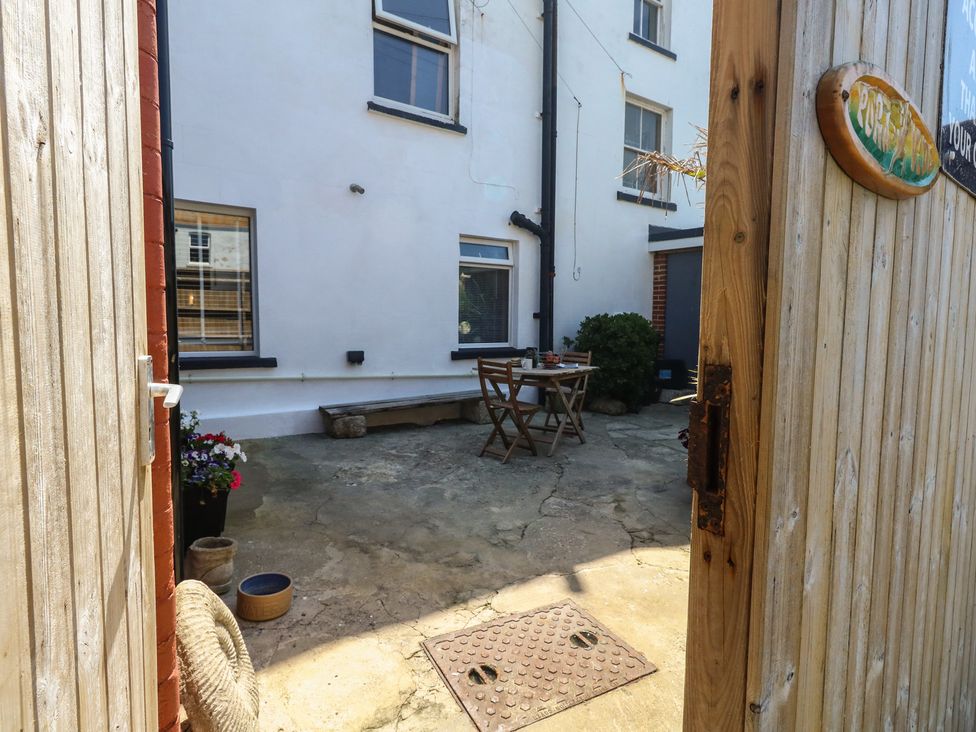 An outdoor patio with a table and chairs at Tipsy Turtle in Weymouth