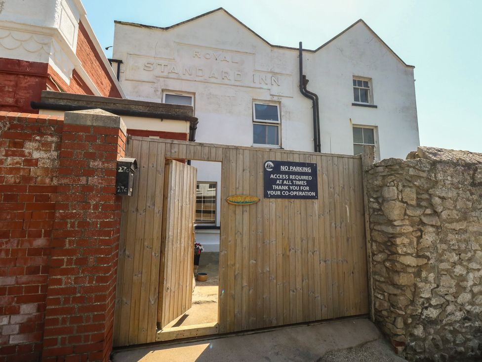 An entrance with a gate and sign at the Royal Standard Inn in Weymouth