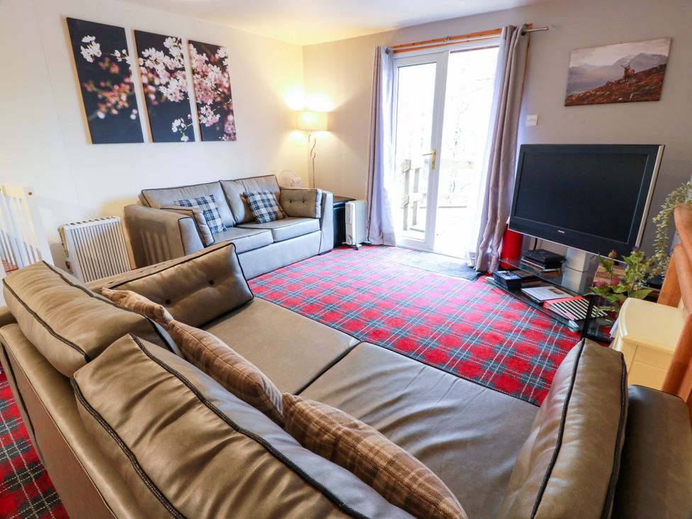 A living room with sofas and a television at Thistle Lodge in Dunoon