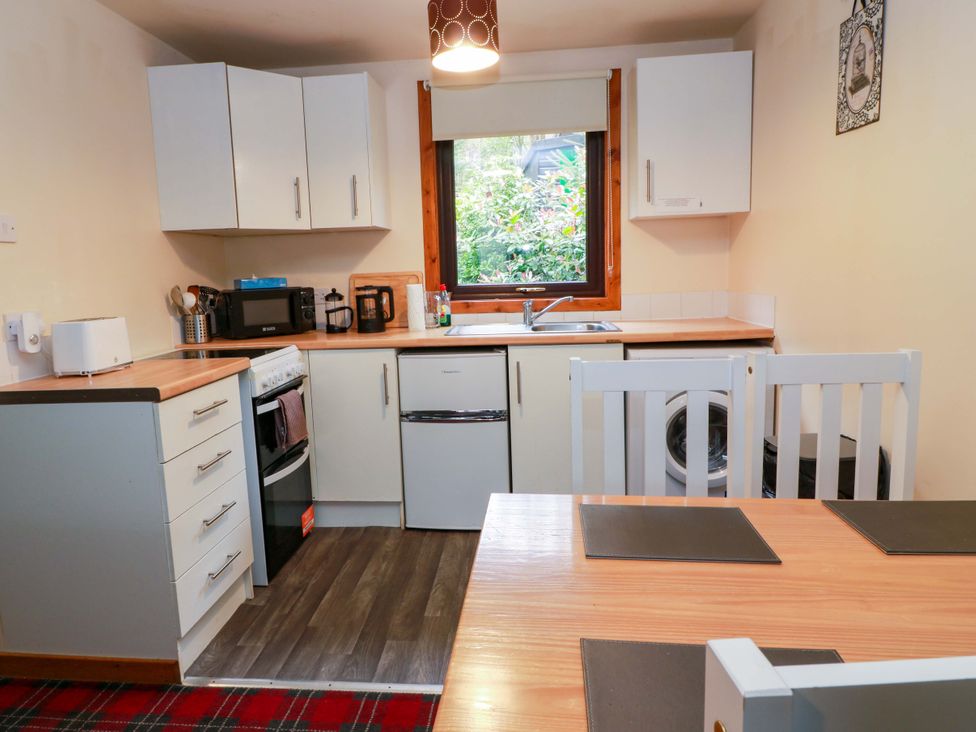 A kitchen with appliances and a table at Thistle Lodge in Dunoon
