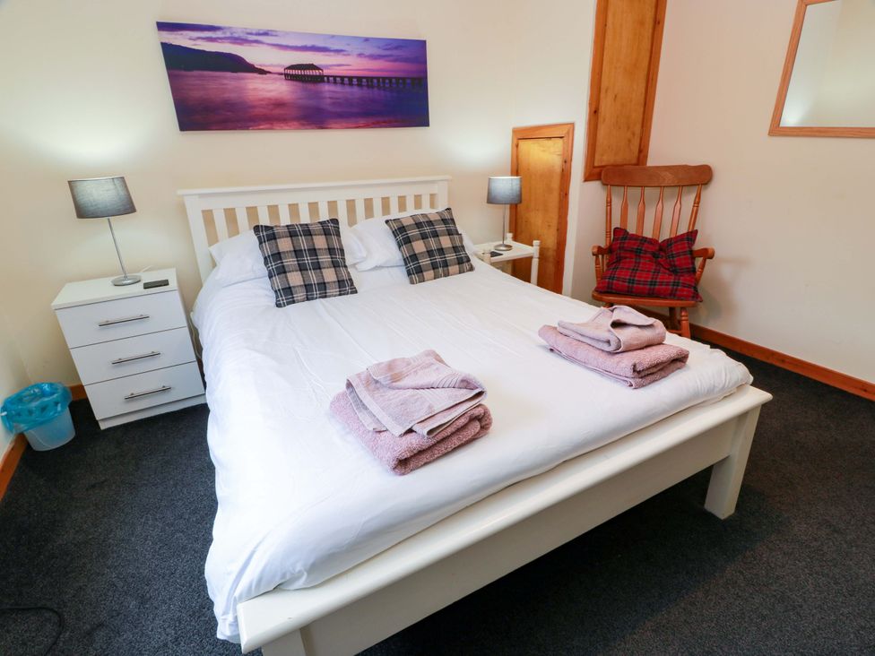 A bedroom with a bed and bedside table at Thistle Lodge in Dunoon