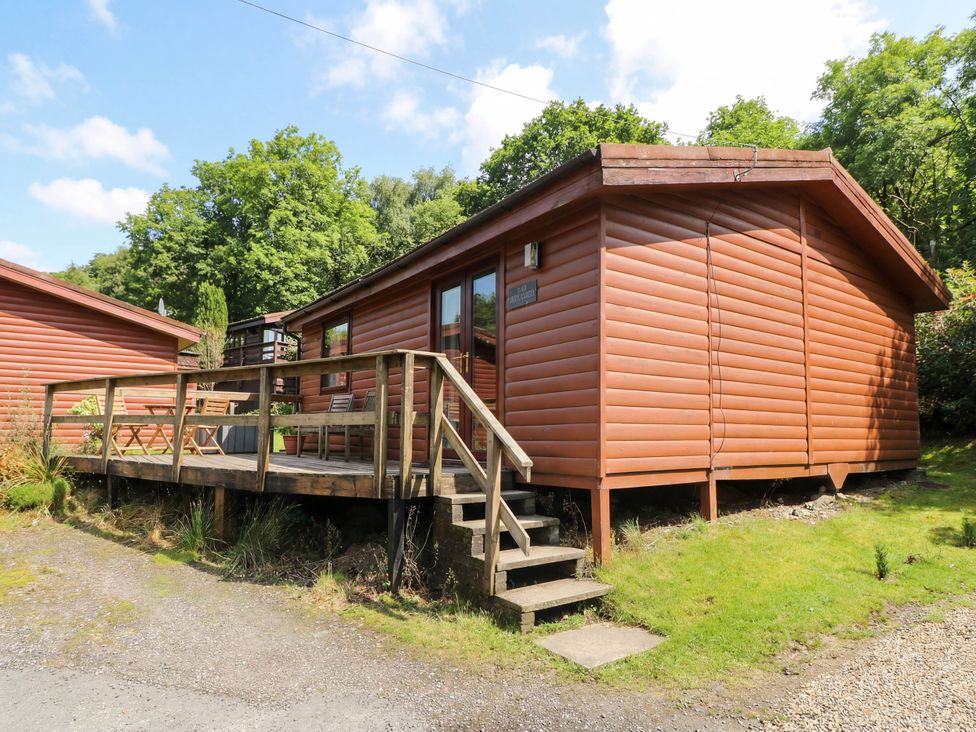 A cabin with a deck and stairs at Thistle Lodge in Dunoon