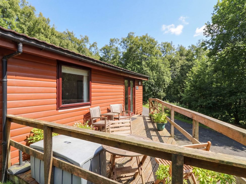 An outdoor deck with chairs and a storage box at Thistle Lodge in Dunoon