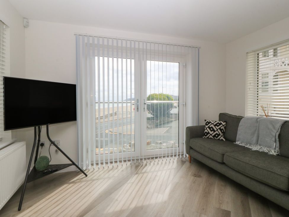 A living room with a television and sofa at 2 Ocean View in Colwyn Bay