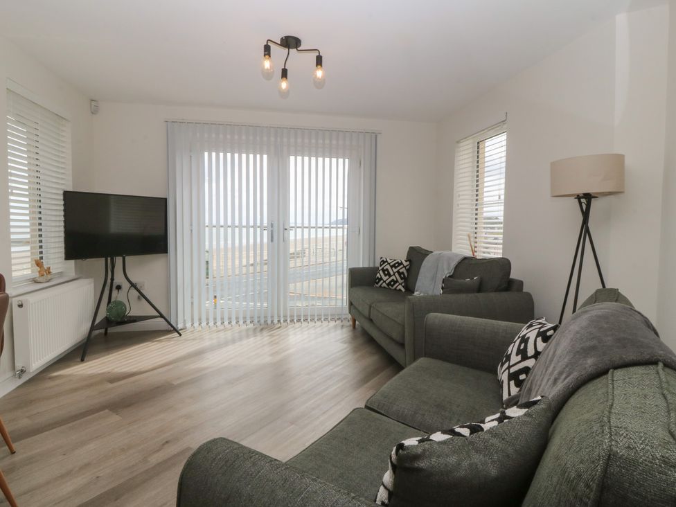 A living room with a television and sofas at 2 Ocean View in Colwyn Bay