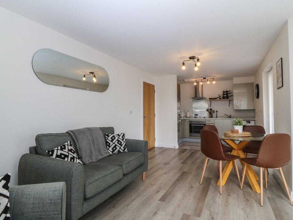 A living room with a sofa and dining table at 2 Ocean View Colwyn Bay