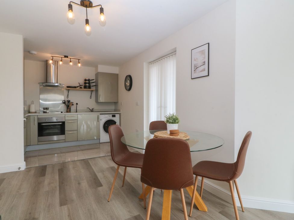A kitchen with dining area and appliances at 2 Ocean View in Colwyn Bay