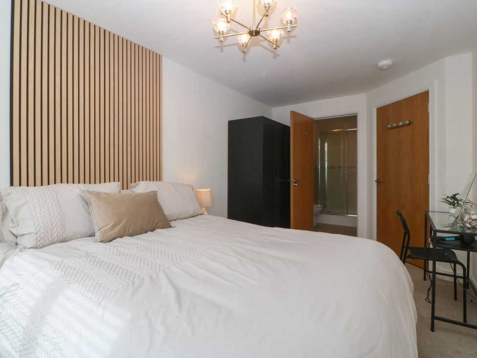 A bedroom with a bed, wardrobe, and bathroom access at 2 Ocean View Colwyn Bay